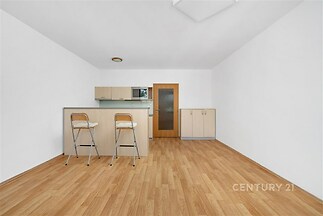 Kuchyňský kout s parketovou podlahou, světlý interiér a vestavěné skříně, nabízí moderní design a útulnou atmosféru.