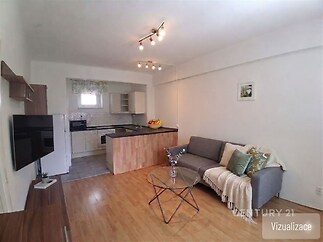 Světlý obývací pokoj s moderní kuchyní, parketová podlaha, vestavěné skříně, elegantní styl, světlé stěny, pohodlná sedačka.