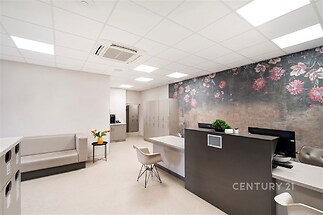 Pracovní prostor s moderním vybavením, dekorativní stěnou s květinovým vzorem a vestavěnými skříněmi, ideální pro komfortní kancelář.