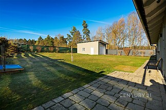 Prostorná zahrada s dlážděnou terasou, udržovaný trávník, moderní plot, samostatná garáž, klidná lokalita.