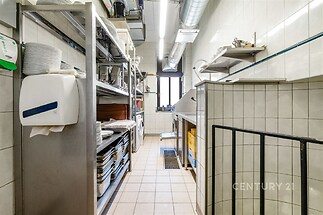 Praktická kuchyň s dlažbou, vybavená moderními spotřebiči a dostatkem úložného prostoru, ideální pro profesionální vaření.