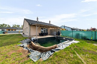 Zahrada s bazénem u moderního rodinného domu, terasa s dlažbou, okolí travnaté.