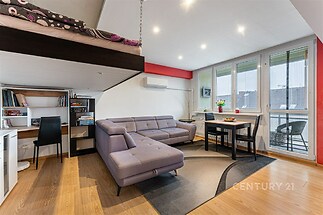 Moderní obývací pokoj s parketovou podlahou, velká okna, světlý interiér, vestavěná pracovna a pohodlná sedací souprava.