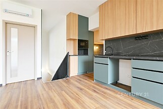 Moderní kuchyň s parketovou podlahou, vestavěné skříně a dřevěné povrchy, světlý prostor s elegantním designem