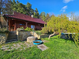 Chalupa na venkově s dřevěnou fasádou, terasou a krásnou zahradou, obklopena přírodou. Ideální pro milovníky klidu a soukromí.