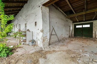 Opuštěná garáž se starou betonovou podlahou a dřevěným stropem nabízí velký prostor k rekonstrukci, zaujme prostorností a autentickým vzhledem.