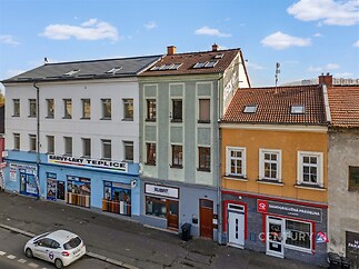 Řadový dům s výkladci, vícepatrový, smíšené fasádní barvy a střešní krytina z tašek, nacházející se ve městě
