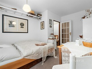 Světlá ložnice s parketovou podlahou, vestavěné skříně a moderní dekorace, vytváří útulné a stylové prostředí pro pohodlné bydlení.