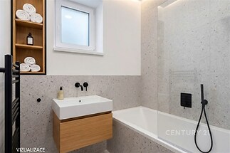 Moderní koupelna s elegantní dlažbou, vanou a vestavěnými skříňkami, světlé prostředí s praktickým úložným prostorem.