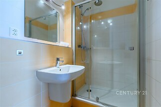 Koupelna s umyvadlem a sprchovým koutem