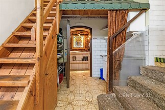 Schodiště s dřevěnými stupni a dlažbou, vedoucí do podkroví. Kachlové obložení a vintage styl, ideální pro rekonstrukci v historickém domě.