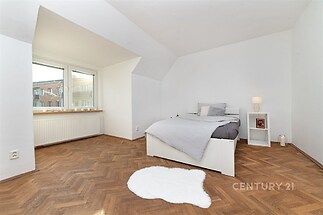 Prostorná ložnice, parketová podlaha, velká okna, moderní styl, světlé stěny, minimalistický nábytek, útulný design.