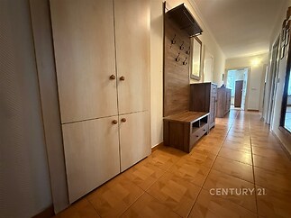 Chodba s parketovou podlahou, vestavěnými skříněmi a moderním nábytkem z dřeva, světlý prostor s dlouhým průchodem.