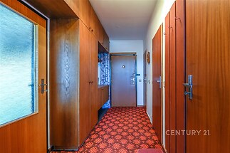 Vstupní hala s dřevěnými dveřmi a vestavěnými skříněmi, retro červený koberec, dřevěné obložení, prostorný úložný prostor, původní stav.