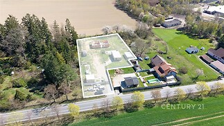 Letecký pohled na pozemek se stavebním pozemkem, obklopený zelení a přístupnou cestou, ideální pro výstavbu rodinného domu.