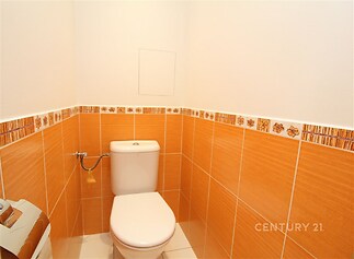 Toaleta s oranžovými dlaždicemi, moderní sanitární zařízení, světlý jednoduchý design
