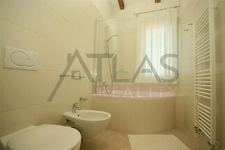 vana s radiátor, toaleta, kachličková podlaha, a přirozené světlo