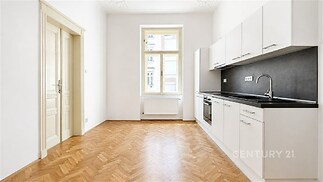 Moderní kuchyň s parketovou podlahou, světlý prostor, vestavěné spotřebiče, velká okna dodávají interiéru vzdušnost.
