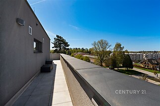 Prostorná terasa s dlažbou nabízí panoramatický výhled, moderní architektura a kvalitní zpracování zajišťují stylové venkovní prostředí.