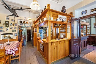 Restaurace s dřevěným barem, dlážděná podlaha, dekorativní strop, útulný interiér, stylový design vhodný pro rodinné podnikání.