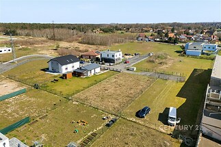 Novostavba domu na prostorném pozemku v klidné oblasti s okolní zelení. Moderní stavba s velkými okny a oplocenou zahradou.