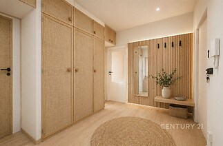 Prostorná chodba se světlou dřevěnou podlahou, vestavěnými skříněmi a moderním osvětlením, vytvářející elegantní a útulný styl.