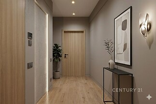 Úzká chodba s dřevěnou podlahou, moderní osvětlení, dekorativní stěna s obrazem, elegantní nábytek, klidný a vkusně zařízený prostor.