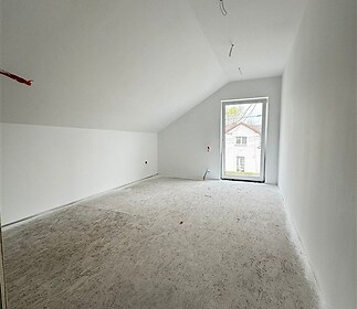 Podkrovní pokoj s velkým oknem, světlý interiér, bílá stěna a strop, betonová podlaha, možnost personalizace prostoru