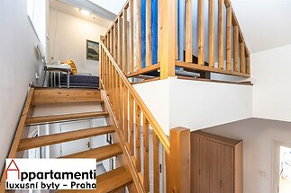 Dřevěné schodiště s moderním zábradlím, světlý interiér, vestavěné skříně, rekonstrukce v podkrovním bytě, přírodní materiály, vysoké stropy.