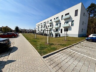 Moderní bytový dům s balkony, parkování na dlážděné ploše, klidná lokalita s přilehlou zelení, ideální pro rodiny nebo investici