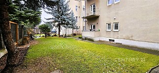 Zahrada s rovnou travnatou plochou, obklopená zástavou, s terasou v přízemí. Disponuje vzrostlými stromy a zpevněnou přístupovou cestou.