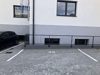 Prázdné parkovací místo s dlažbou, označené číslem 39, vedle moderní budovy. Vhodné pro parkování rezidentů v městské oblasti.