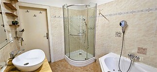 Koupelna s moderní sprchovým koutem, keramickou dlažbou a vanou, nabízí světlý a čistý prostor.