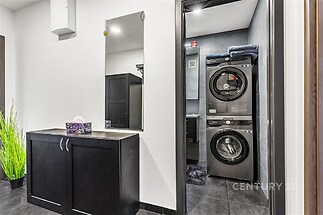 Prádelna s moderními spotřebiči, dlažba a vestavěné skříně, světlé stěny, účelné využití prostoru, pohodlné uspořádání.