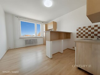 Světlá kuchyň s parketovou podlahou a vestavěnými skříněmi nabízí moderní design a velká okna zajišťují dostatek přirozeného světla.