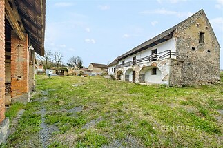Rustikální dvůr s historickou kamennou stodolou nabízí rozlehlou travnatou plochu a původní architekturu. Ideální pro rekonstrukci.