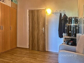 Chodba s dřevěnou podlahou, vestavěné skříně, moderní osvětlení, světlé stěny a prostorný úložný prostor.