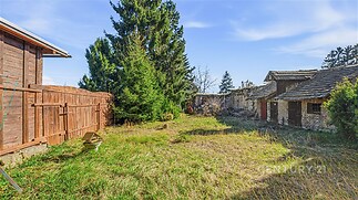 Rozlehlá zahrada s travnatou plochou a vzrostlými stromy, oplocená dřevěným plotem, vhodná pro rekonstrukci nebo nové možnosti, klidná lokalita.