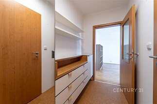 Chodba s vestavěnými skříněmi a dřevěnou podlahou, moderní interiér, propojení s obývacím pokojem s parketovou podlahou