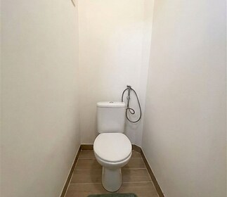 Útulná toaleta s dlažbou, světlými stěnami a moderní sanitární keramikou.