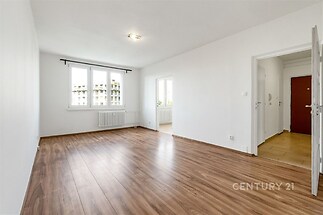 Světlý obývací pokoj s parketovou podlahou, velkými okny a moderním stylem. Propojení do kuchyně, nově rekonstruovaný prostor.