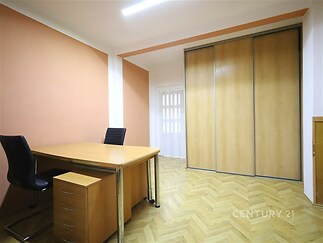 Kancelářský prostor s parketovou podlahou, vestavěné skříně a moderní úprava.