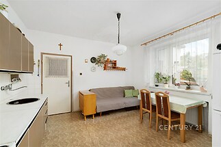 Jídelní kout s dlažbou, velkým oknem a světlým interiérem nabízí prostor pro útulné posezení u jídelního stolu, ideální pro rodinné obědy.