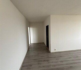 Světlá chodba s laminátovou podlahou a bílými stěnami nabízí moderní design a připravená k okamžitému nastěhování.