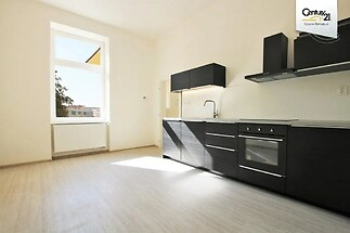 kuchyně s přirozené světlo, trouba, digestoř, dřevěná podlaha, a černé skříňky