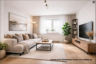 Světlý obývací pokoj s parketovou podlahou, moderní nábytkem a velkými okny, které zajišťují dostatek přirozeného světla.