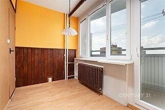 Světlý pokoj s parketovou podlahou, velkými okny a dřevěným obložením stěn, ideální pro moderní interiérové úpravy.