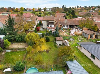 Zahrada s rozmanitou zelení a bazénem, nabízí klidné prostředí v rezidenční čtvrti, ideální pro rodinnou relaxaci a zahradničení.