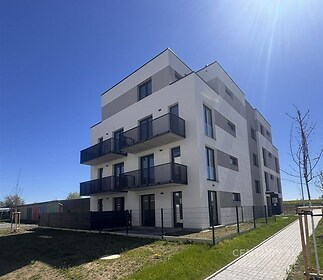 Moderní bytový dům s balkony, bílá fasáda, minimalistický styl, klidná lokalita, skvělá dostupnost, novostavba, prosluněné pokoje