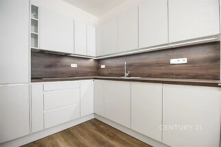 kuchyně s ploché panelové skříňky, dřevěná podlaha, bílé skříně, a backsplash